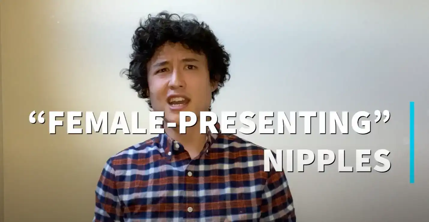 A photo of Ben Pettis standing in front of a blank wall with a confused look on his face. There is photo over the image which reads 'Female-Presenting Nipples'