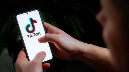 Person holding a phone with TikTok on the screen